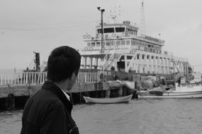 black and white photo of a man on the background of the ship