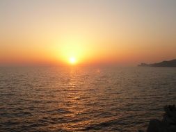 sun on a yellow sky on the horizon of the sea