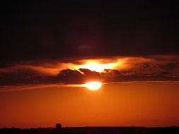 fiery sun and orange sky on the horizon above the city