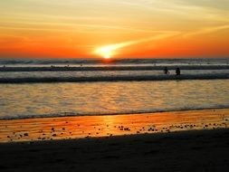 swiming people silhouettes in colorful sunset seascape