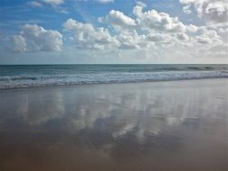 reflection of clouds on the beach of the sea