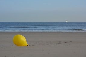 Yellow buoy on sea sand beach