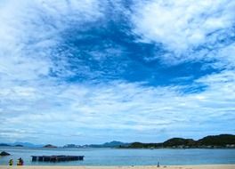 white clouds in the sky over the lake