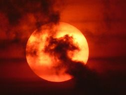 yellow sun in dark clouds, sunset