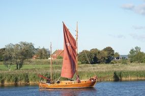 wooden sailing boat at bank in countryside