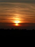 the sun behind the clouds in the evening sky