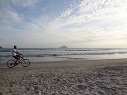 man cycling on the beach