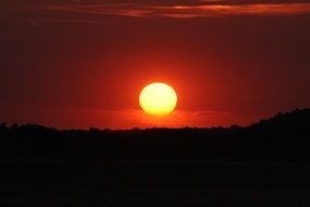 round sun over the horizon in sunset