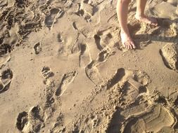 footprints and bare feet in the sand