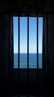 view through the bars to the blue ocean