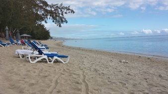 Colorful sun loungers and parasols on the sandy beach