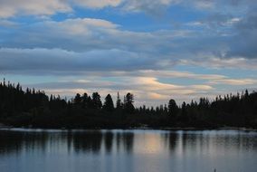 tranquille twilight on glossy lake at forest