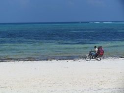 man on a moped on the sandy coast