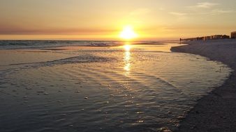 reflection of the setting sun in the sea near the beach