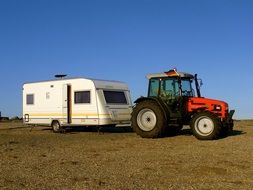 red tractor and autohouse on a green meadow
