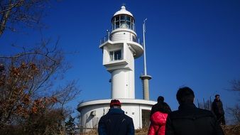 people near the lighthouse