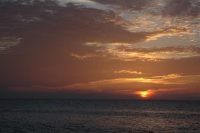 cloudy sunset above dark sea