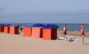 red tents and sun loungers on the beach