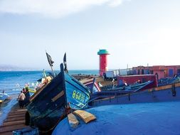 boats on beach at lighthouse, morocco, imsouane