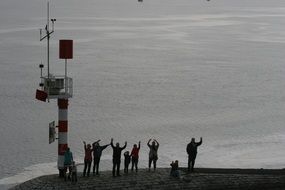people waving standing on a boat