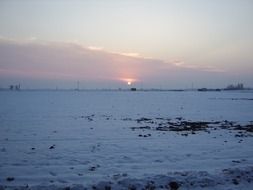 snowy plowed field covered at sunset