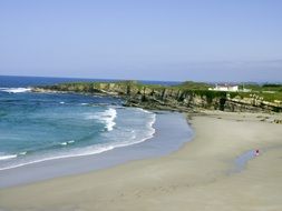 gray sand and green hills by the sea