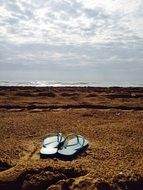 slippers on the sandy beach on a sunny day