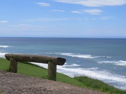 wooden bench made of logs by the sea