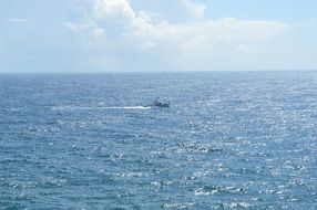 boat fishing on gleaming sea surface