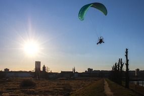 flying glider at shining sun background