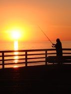 silhouette of a fisherman at sunset