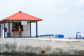 people near a wooden beach hut
