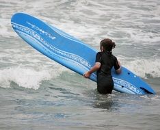 surfer with a blue board in the ocean