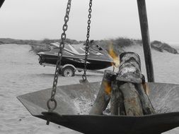 black and white photo of a bonfire on the beach