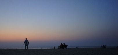 silhouettes of people on a beach at sunset