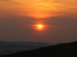 sunset in the evening sky over the hills