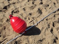 red buoy on the beach sand