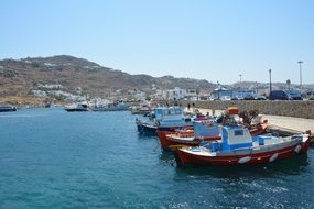 boats near the pier at the foot of the mountains