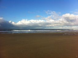 white clouds in the sky over the beach