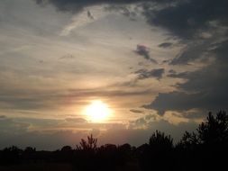 gray clouds and bright sun at sunset