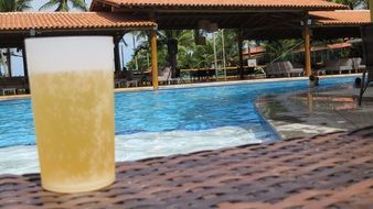 a glass of beer on the side of the pool in Brazil