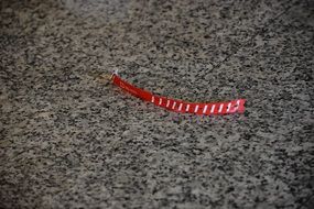 Red stick on marble airport floor