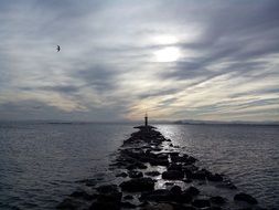 stone path to the lighthouse on the sea