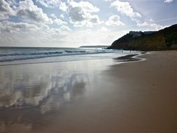 reflection of clouds in the wet sand