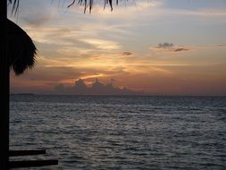 view of the sunset on the horizon on a tropical island