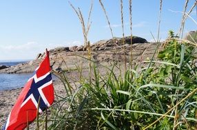 flag of norway on a rocky shore