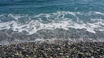 sea waves splashing on grey pebble beach, taiwan