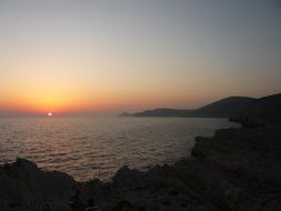 view of the sunset on the horizon of the sea