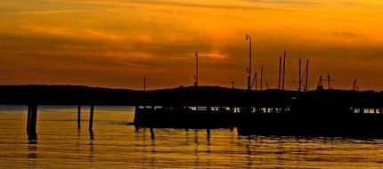 silhouette of ships on the water in the evening