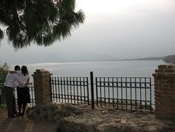 couple in love stands near the gate on the beach